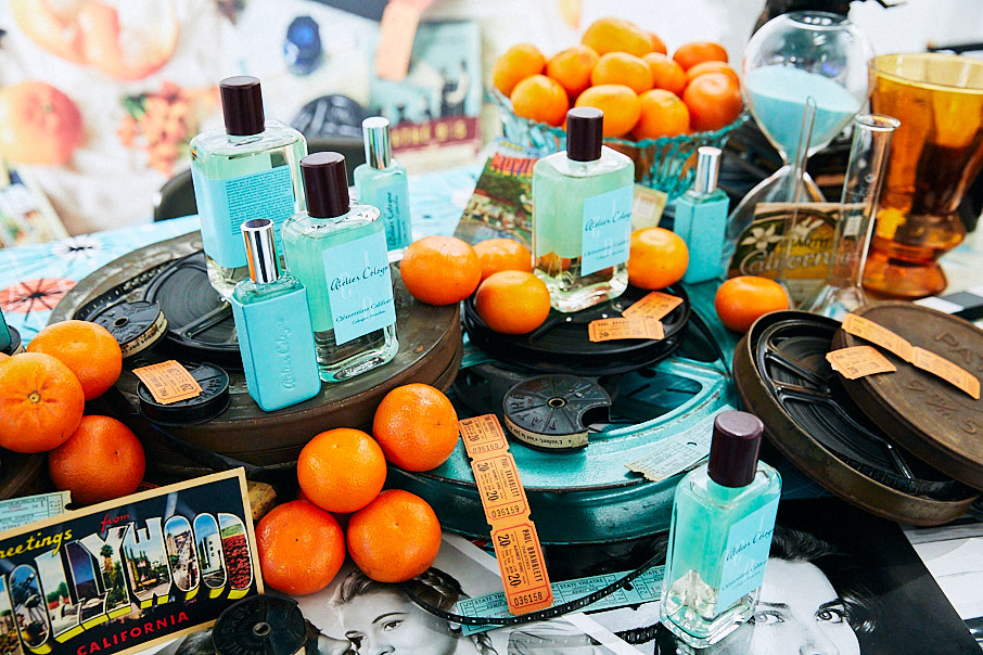 instore display of blue bottles of fragrance with old film stills and oranges