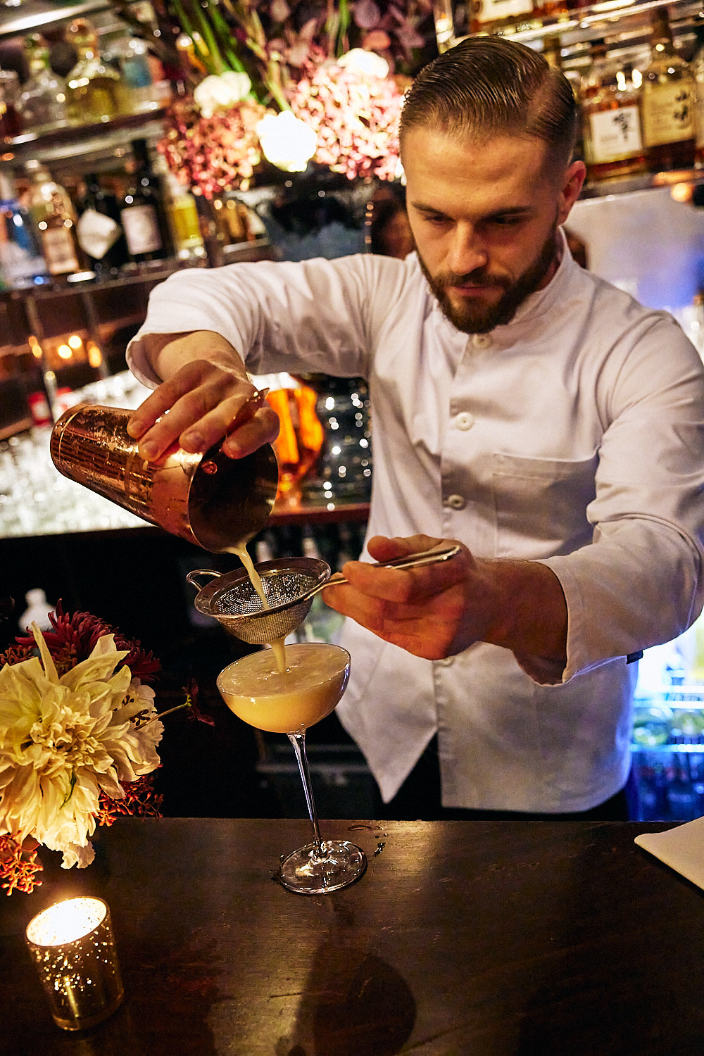 Bartender pouring a cocktail in a bar