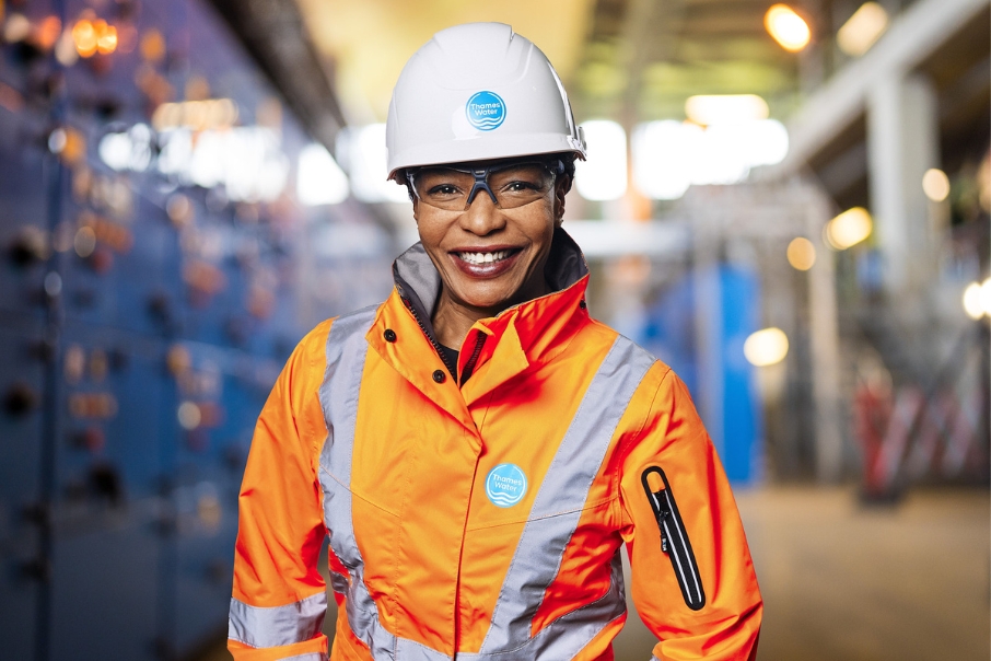 Headshot of a woman in a Thames Water hard hat and orange jacket on site