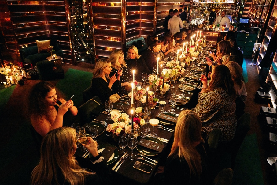 Beautiful evening event photography of people sitting around a candlelight table