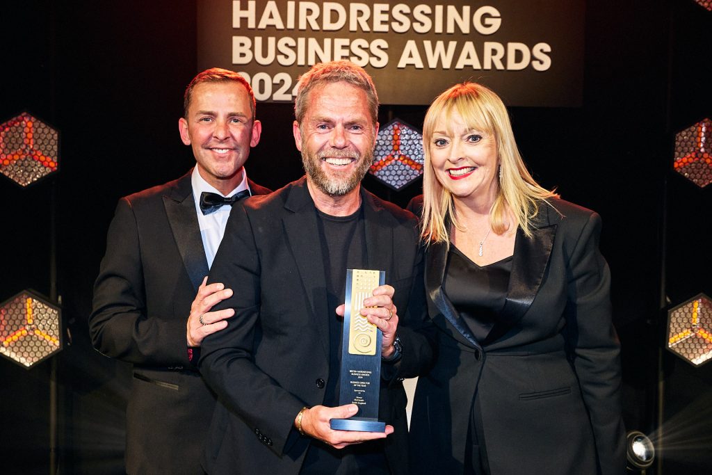 Man accepting an award on stage at the British Hairdressing Business Awards